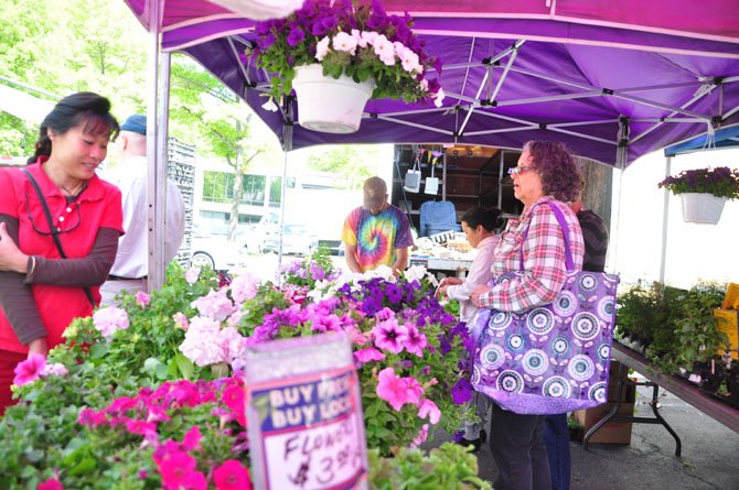 Customers at the Reston Farmers Market browse flowers for sale by Glascock’s Produce Saturday, May 4. 