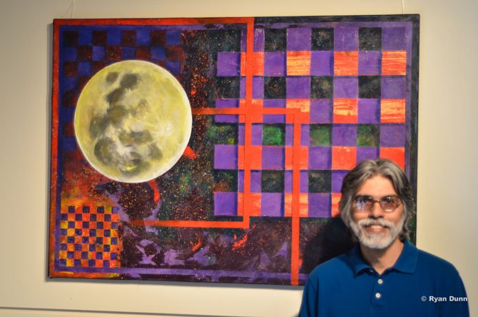 Art instructor Arnold Lopes standing by his piece "Flower Moon."
