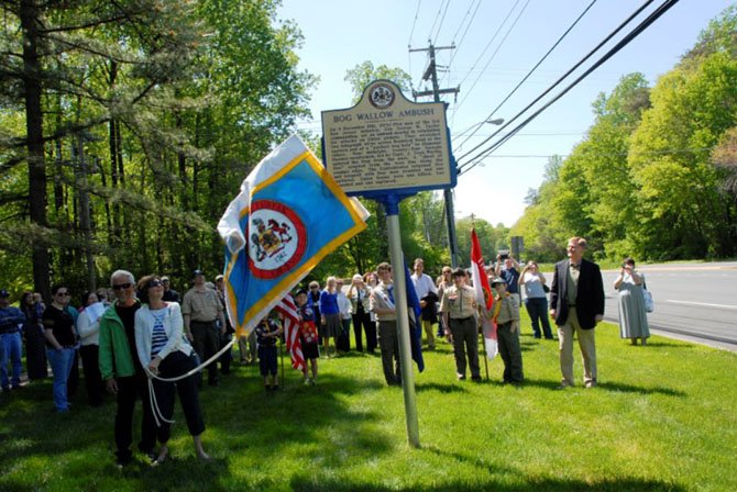 Braddock Supervisor John Cook (right) watches as Patty and Robert Kozak, descendants of the Union scout who planned the ambush, unveil the new historical marker commemorating the Bog Wallow Ambush of 1861.
