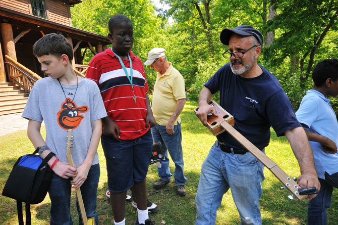 Joe Youcha, director of Alexandria Seaport Foundation’s Building to Teach Program, works on tuning a cigar box guitar.