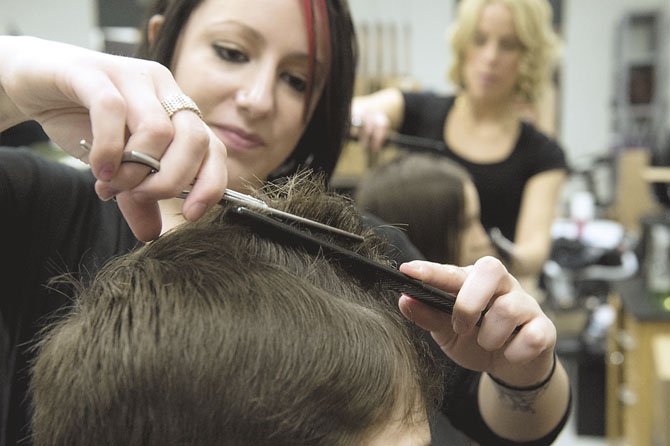 Andie Modra, 2011 graduate of the Chantilly Academy Cosmology program and professional stylist provides Daniel Manik with a haircut at the program’s annual Cut-A-Thon. In the background, 2006 graduate Allison Brown provides a cut to Caroline Manik. Brown has returned numerous times to the program’s fundraisers and has her own business, Allison’s Hair Design (www.abhairdesign.com).
