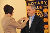 Laura Hills, president of The Rotary Club of Fairfax, pins a Rotary pin on GMU President Dr. Cabrera’s lapel. The pin, a symbol of Rotary, was given to Dr. Cabrera during his induction as an honorary member of the club.