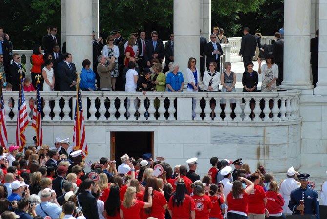 First lady Michelle Obama (upper right) waves to the crowd in the amphitheater at Arlington National Cemetery.