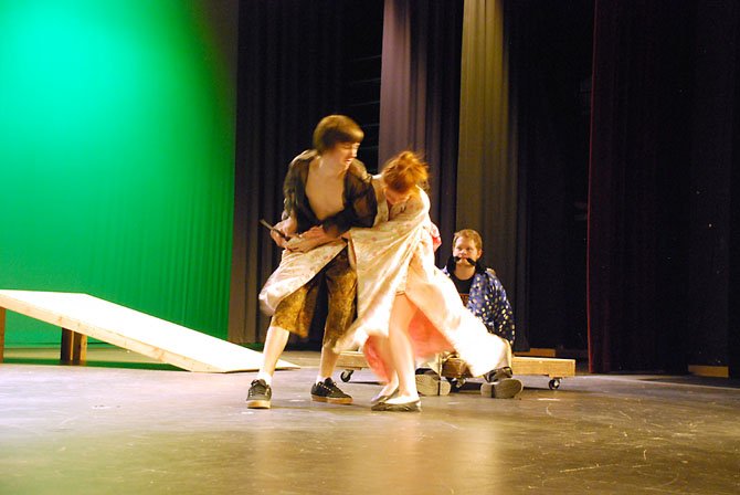 Sophomore Liam Finn (left) and senior Sarah Beck play-struggle during a rehearsal for Lake Braddock’s production of “Rashomon,” while senior Zach Newby’s character can only observe from the sideline.