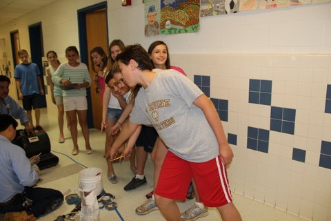 From left, Churchill Road sixth graders Luke Voorheis, Simrin Jeddy, Helen Bascom, Katie Holzapfel, Gillian Weed, David Suratgar, Lindsay Nyquist, Amanda Ugone and Jacob Backes are happy to find examples of wedges and levers on the science scavenger hunt.