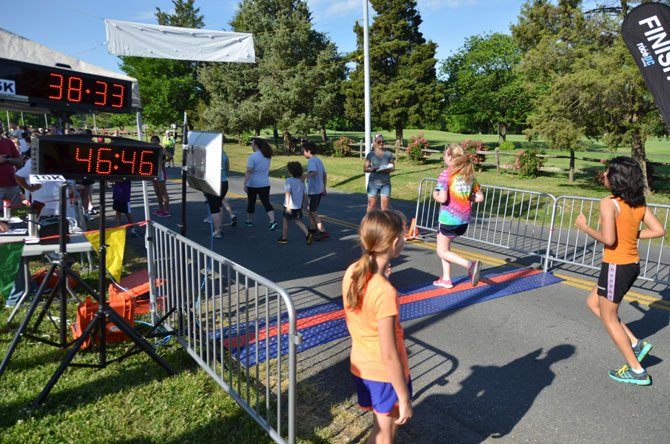 Racers cross the finish line near the Herndon Community Center for the Hendon Festival 5K/10K.