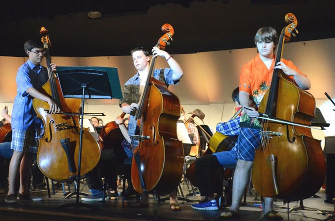 Langley Philharmonic Orchestra string basses surprise the concert audience with their rendition of a song made famous by the Beach Boys. From left are: Jonathan Grow (freshman), Alex Blankinship (junior) and Matt Cooley (senior).  