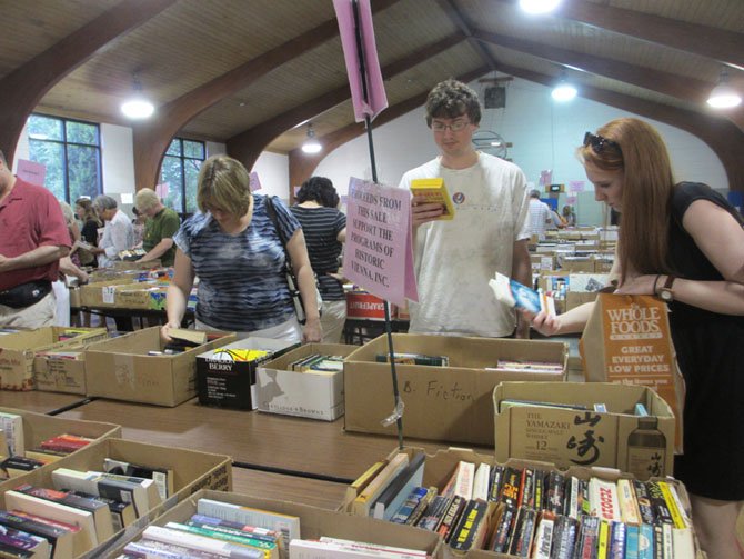 Shoppers take their time looking through the 1,200 boxes of books at Historic Vienna, Inc.’s book sale at the Vienna Community Center.