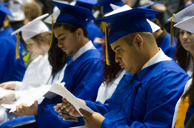 Ali Hossam Abdelhamid looks at his just-awarded diploma at the Robinson High School Commencement Ceremony on June 13.
