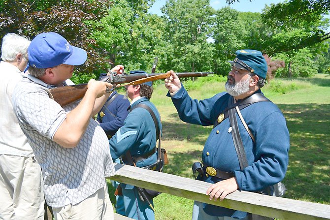 Paul Vaselopulos, right, demonstrates how to use a musket.