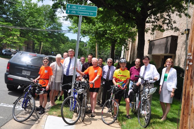 County staff and bicycling advocates gather at one of the new bicycle wayfinding signs in downtown McLean Thursday, June 20. 