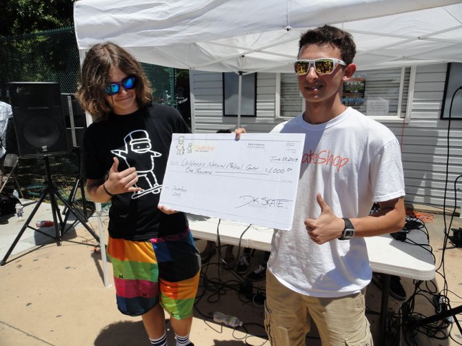 Dominic Doyle (left) and Luke Kennedy present a $1,000 check to Children’s Hospital from DK Skate.