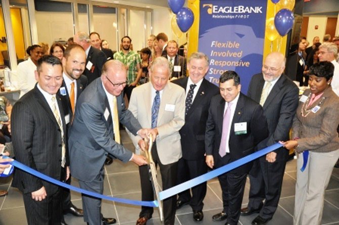 EagleBank celebrated the opening of its newest branch in Old Town with a ribbon cutting ceremony June 19. From left: EagleBank area manager Juan Jara; head of retail operations Joe Clarke; Eagle Bank CEO Ron Paul; vice chairman Bob Pincus; Alexandria Chamber of Commerce chair John Renner; EagleBank branch manager Ed Velarde; Chamber of Commerce CEO John Long, and branch assistant Portia Reid.
