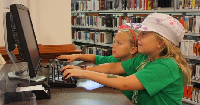 Sisters Kaiya and Chiara sign up for the Summer Reading Program at one of the City of Fairfax Regional Library’s computers. Participants can sign up online at home, or at a Fairfax County library.