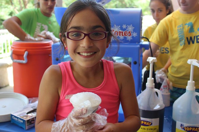 Emelia Isola, 10, helps to sell snow cones during Summer at WES camp to benefit House With A Heart, a senior pet Sanctuary in Gaithersburg.