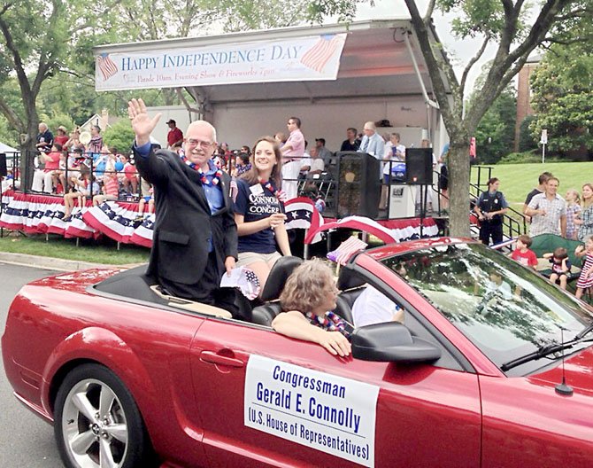 U.S. Rep. Gerry Connolly (D-11), his wife "Smitty," and daughter Caitlin greet well-wishers along the City of Fairfax Fourth of July parade route.  Connolly and his family celebrated at parades in Fairfax, Dale City and Lake Barcroft.