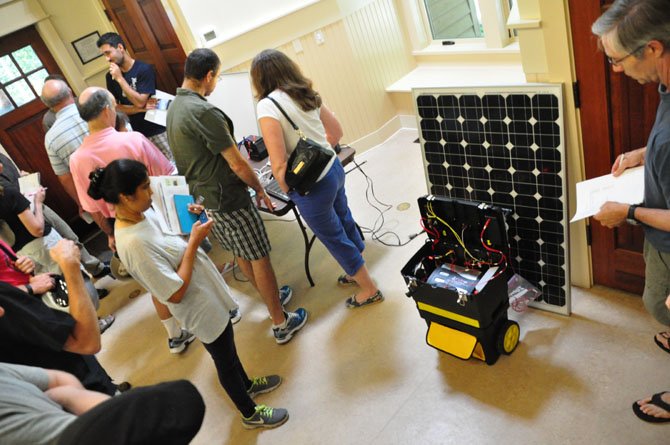 Visitors to the Reston Energy Fair examine a portable solar powered generator Sunday, July 14. 