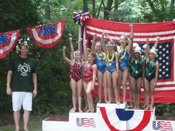 The Kingston Chase (Sydney Douglas, Scout McClain, Mackenzie Kleczynski, Casey Mills), Hiddenbrook (Maddie Morin, Audrey Ferguson, Alyssa Landrum, Kate Keane) and Herndon Community Center (Sophia Lee, Shreshtha Peter Rai, Rachel Sim, Chloe Thomson) 8 & Under Girls 100 Meter Freestyle Relay teams pose with Josh Davis on the Herndon Olympics podium.