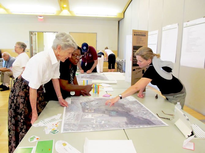 Joy Koeppen, far right, points out a possible location for a handicapped-accessible playground on a map of Van Dyck Park to Diane Henn and Vicki Woods during a public workshop at the Sherwood Community Center on Sunday, June 23. 