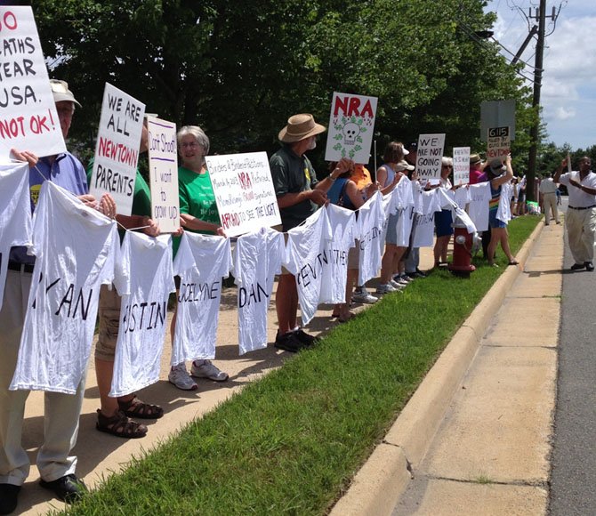 Members of the Reston-Herndon Alliance to End Gun Violence and local community members hold a vigil outside NRA headquarters to honor victims of shootings.