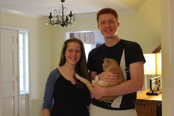 Siblings Caroline and James Bollinger of McLean stand with one of their three cats, Lizzie.