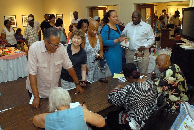 Patrons queue up to have their books signed by three of the authors, James Henson, Sr., Char McCargo Bah and Christa Watters.