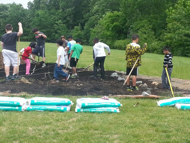 Centreville Elementary fourth-graders work the soil inside their map of Virginia.