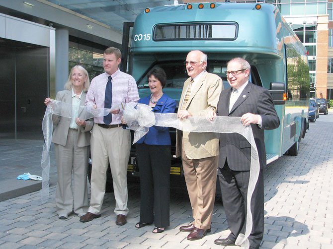 Elected officials cut the ribbon during a ceremony announcing the addition of six new TAGS buses in Alexandria July 17. From left, Del. Vivian Watts (D-39), Supervisor Jeff McKay (D-Lee), Fairfax County Board of Supervisors Chairman Sharon Bulova (D-at-large), TAGS official Jack Mutterelli, and Del. Mark Sickles (D-43).