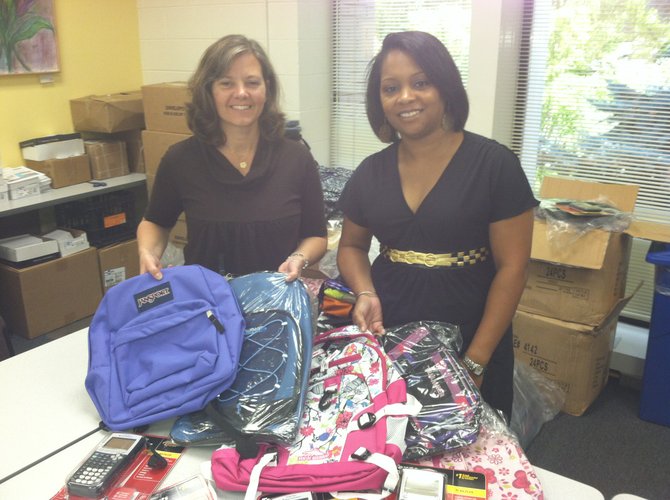 Displaying backpacks and calculators are (from left): Lisa Whetzel, executive director of Our Daily Bread, with Dawn Sykes, season and holiday programs manager.