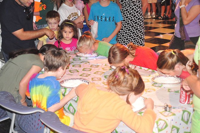 Children participate in a pie-eating contest at last year’s Old Firehouse Teen Center Block Party. This year’s event will take place Saturday, Aug. 24. 