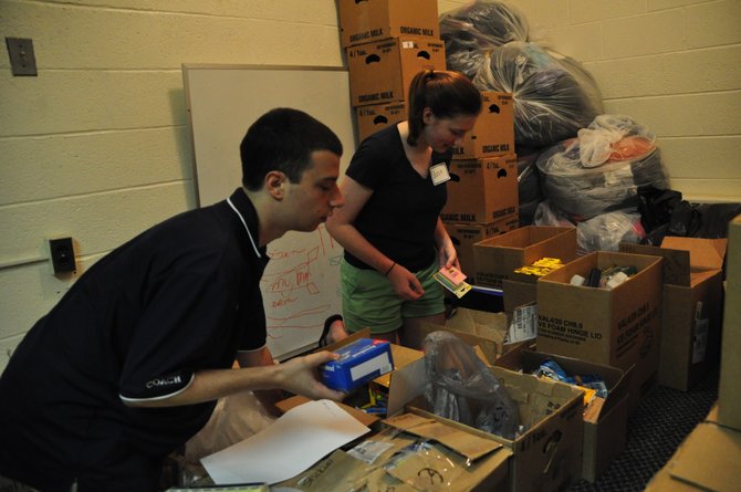 From left, Share volunteers Jack Buttarazzi and Lizzie Gidley sort donated school supplies for Share clients Wednesday, Aug. 14, part of Share’s back-to-school drive. 