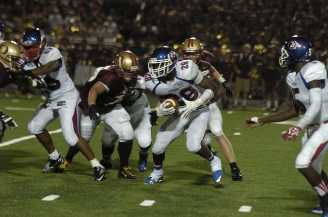 T.C. Williams running back Malik Carney carries the football against Oakton on Friday night.
