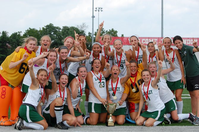 The Langley field hockey team celebrates with the trophy after winning the Herndon Invitational.