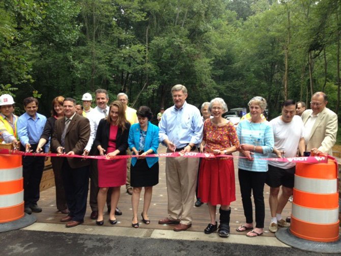 VDOT Bridge Engineer Nick Roper, elected officials State Senator Barbara Favola and Supervisor John Foust, resident Candice Burt and others cut ribbon to open the bridge.
