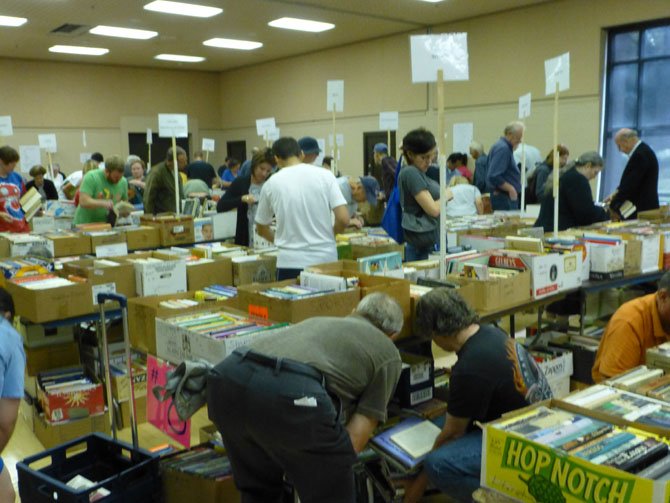 A photo from the last year’s book sale: The many thousands of individual books and CDs and DVDs have been well sorted and will be displayed in clearly labeled and logical categories.
