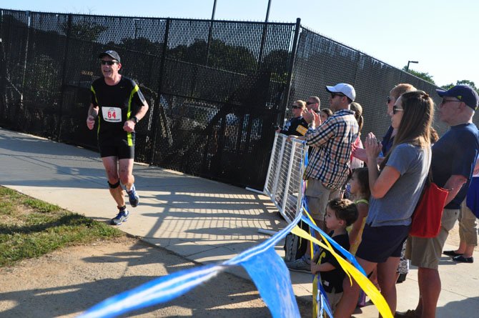 The crowd at the Reston Triathlon cheers David Cruley as he prepares to take a lap around the South Lakes High School track and complete the event Sunday, Sept. 8. 