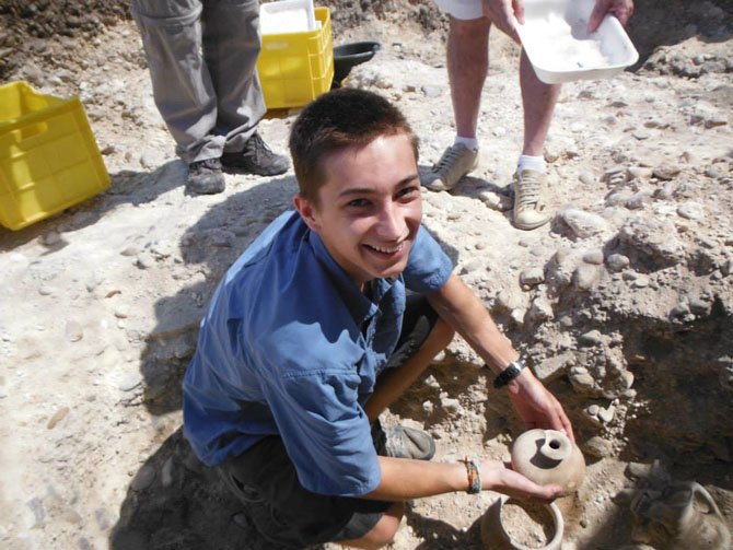 Ben Raymond holding a pot he had uncovered from the tomb.
