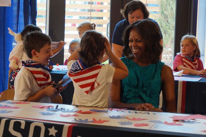 Michelle Obama admires the crafts of some of the children in attendance on Wednesday.