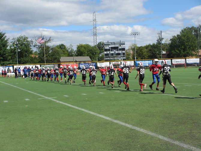 The 80-pound division Vienna Wolfpack and Ft. Hunt Titan share post-game sportsmanship. Vienna won the season opener 13–12.