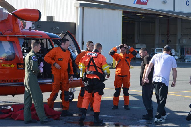 Coast Guard Lt. Brian Ward (third from the right) acted as aircraft commander for the mission to rescue two fishermen (first and second from the right) after their boat mysteriously began sinking.