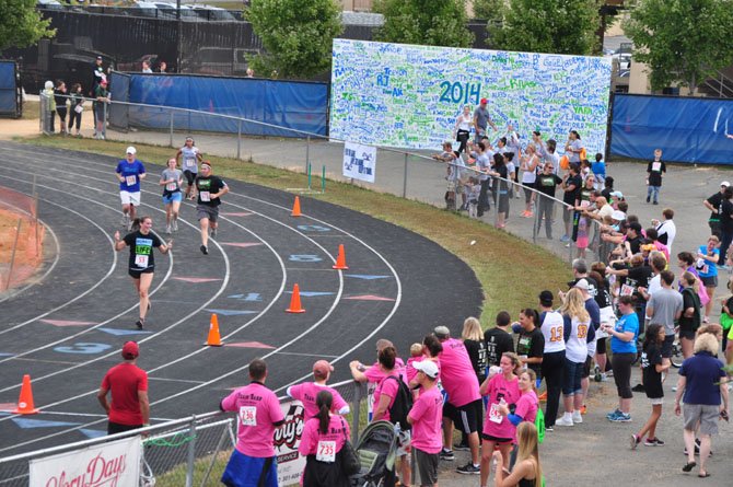 Spectators cheer runners in the Tim Susco 8K as they enter the track at South Lakes High School Saturday, Sept. 21. 