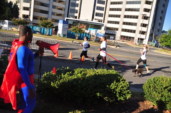 Dan Brazelton, dressed as Superman, cheers runners as they cross the finish line at the 10th annual Super H 5K Sunday, Sept. 22. 