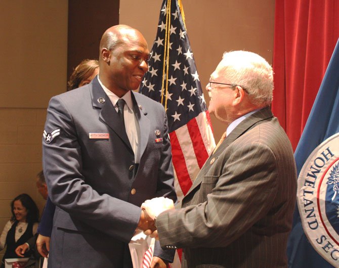 >Class Peter Nketia-Akonnor from Ghana, who serves in the Air National Guard at Joint Base Andrews, smiles proudly as Congressman Gerry Connolly congratulates him on becoming a U.S. citizen.