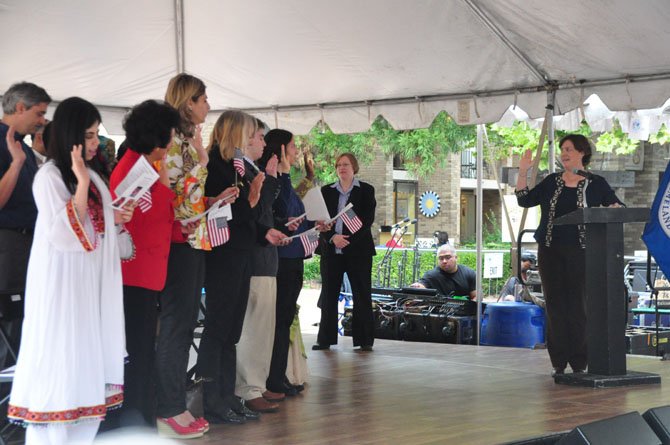 Sarah Taylor, Washington District director of U.S. Citizen and Immigration Services, leads 25 new immigrants in the Oath of Allegiance Saturday, Sept. 28. 