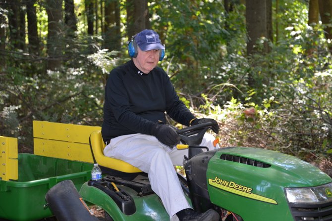 Neighbor Harold Schroeder was “just happy to be asked to help,” he said. Schroeder brought his John Deere rider to use it in the Work Day at Stuart Road Park in Reston, organized by Boy Scout Ethan McKnight.