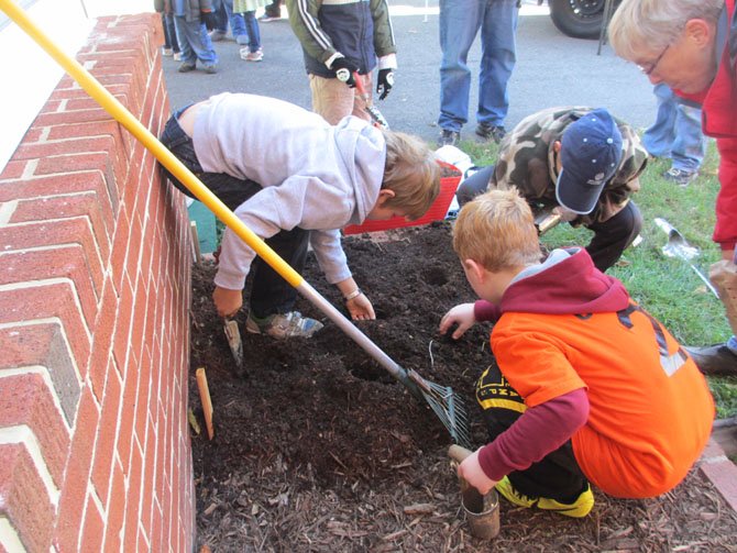 The Ayr Hill Garden Club and farmers market master Sarah Jane Brady helped visiting children to plant spring bulbs at Faith Baptist Church. The church lent the market its grounds for the market season.