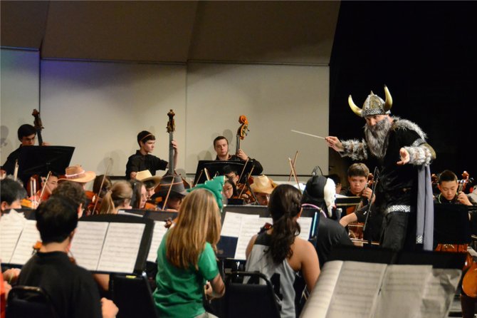 Disguised as the school mascot, the Langley Saxon, Dr. Scott McCormick conducts the Sophomore Orchestra.
