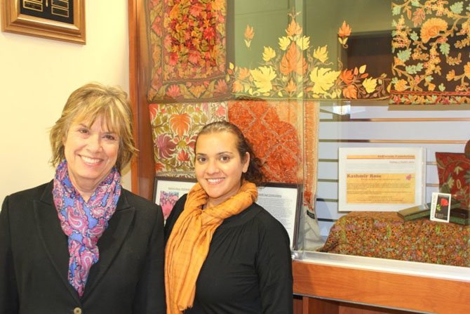 Great Falls Library Branch Manager Daniela Dixon and Princess Aliyah in front of Kashmir Rose shawl displays. 