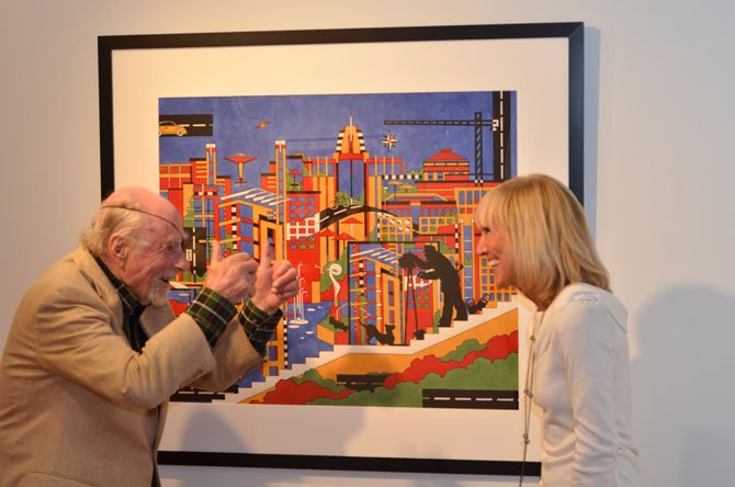 Reston founder Robert "Bob" Simon poses for a photo with Reston artist Dana Scheurer. In the image is a black silhouette of Simon. 