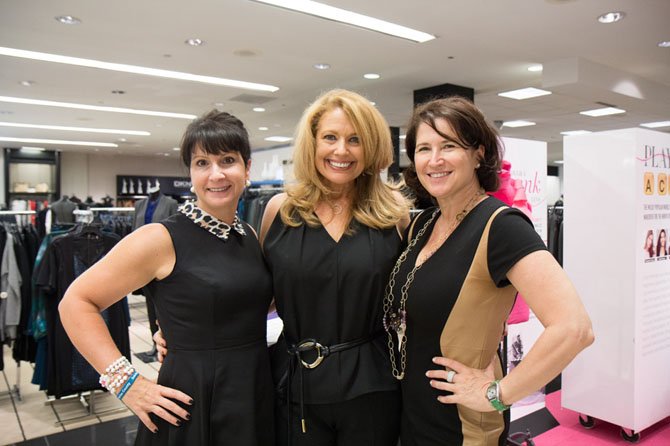Emcee Rebecca Cooper of WJLA/ABC7 (center) shares a triumphant moment with SafeSpot Fashion show Co-Chairs Suzanne Singer (left) and Debbie Copito (right) of Great Falls.